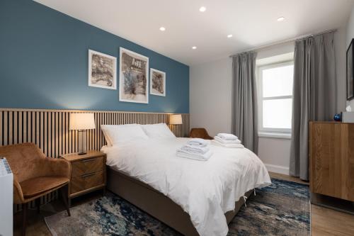 a bedroom with a bed with a blue wall at The Ford Apartment in Perth