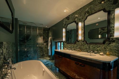 a bathroom with a tub and a sink and mirror at CASABIANCA Suites in Como