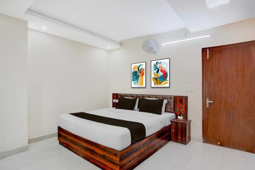 a bedroom with a large bed and a wooden door at Super Townhouse Oak ISBT Bus Terminal Dehradun Formerly Hotel Himalayan in Dehradun