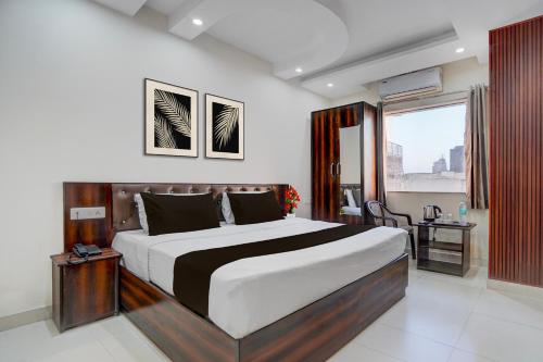 a bedroom with a large bed and a window at Super Townhouse Oak ISBT Bus Terminal Dehradun Formerly Hotel Himalayan in Dehradun