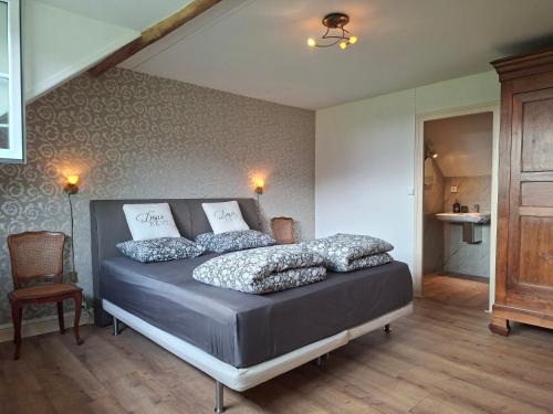 a bedroom with a bed with pillows on it at C'est Si Bon in Vandenesse