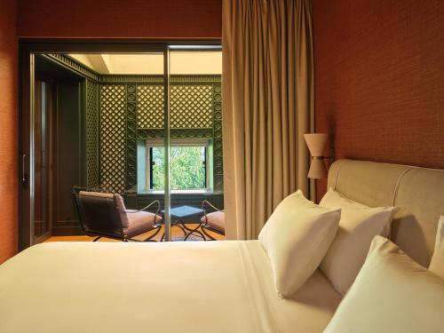 a bedroom with a bed and a chair and a window at CASABIANCA Suites in Como