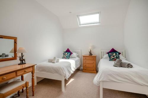 a bedroom with two beds and a dresser and a mirror at 2 Bed in Driffield oc-79279 in Wold Newton
