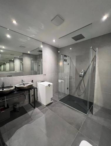 a bathroom with a shower and two sinks and a shower stall at Luxury Marina apartments in Rijeka