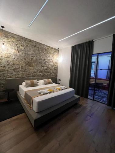 a bedroom with a large bed and a brick wall at Luxury Marina apartments in Rijeka