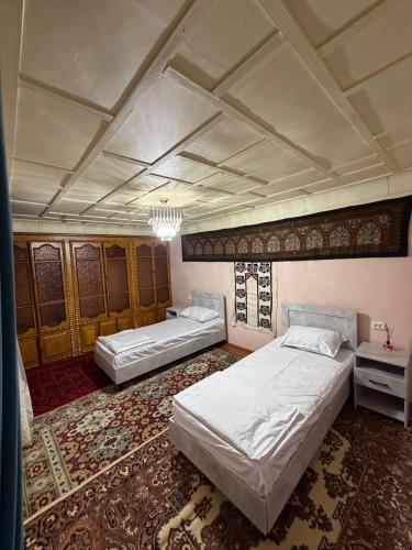 a bedroom with two beds and a chandelier at Aziz Guest House in Samarkand