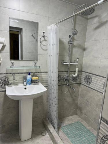 a bathroom with a white sink and a shower at Aziz Guest House in Samarkand