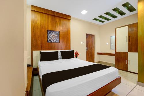 a bedroom with a large bed in a room at Townhouse Oak Kozhikode Bus Stand Formerly Nextel Inn in Kozhikode