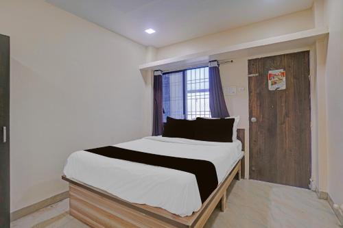 a bedroom with a large bed with a window at Collection O Iskcon Aurangabad Formerly Everest Inn in Chikalthān