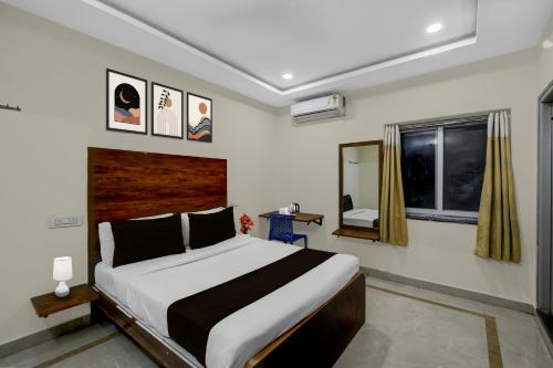 a bedroom with a large bed and a window at Super Townhouse Financial District Gachibowli Formerly Srinika Inn in Hyderabad