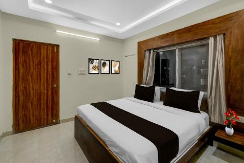 a bedroom with a large bed and a window at Super Townhouse Financial District Gachibowli Formerly Srinika Inn in Hyderabad