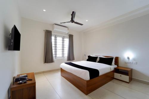 a bedroom with a large bed and a window at Collection O Kottayam Railway Station in Kottayam