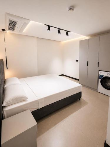 a white bedroom with a bed and a washing machine at Bodrum Has Apart Otel in Bodrum City