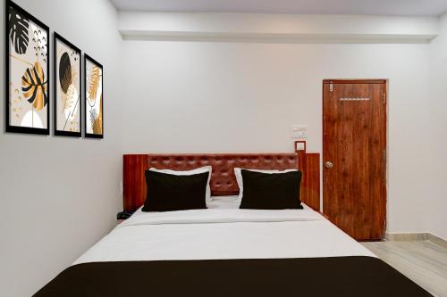 a bedroom with a large bed with a wooden headboard at Super Townhouse Telapur Junction Formerly Fortune Inn in Hyderabad