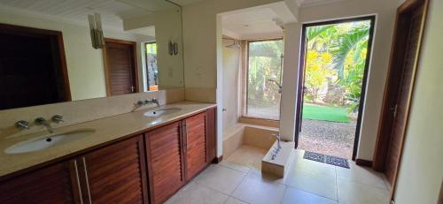 a bathroom with two sinks and a large window at Villa 24 in Grand-Baie