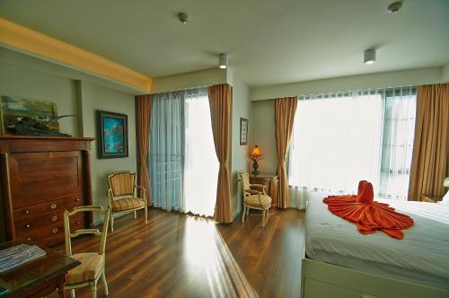 a bedroom with a bed with a red dress on it at 6th Avenue Surin Beach in Surin Beach