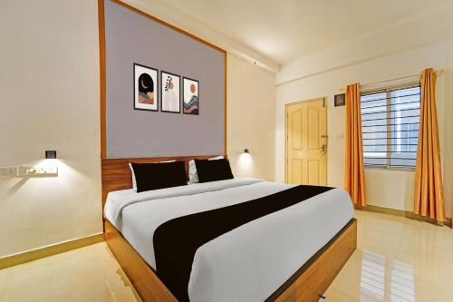 a bedroom with a large bed and a window at Townhouse Kozhencherry Formerly The Beige Hotel in Pathanāmthitta
