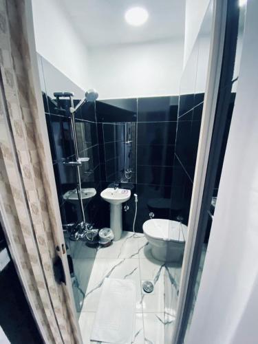 a black and white bathroom with a toilet and sink at Nada HOTEL in Cairo