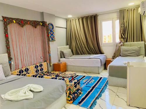 a bedroom with two beds and a room with two windows at Nada HOTEL in Cairo