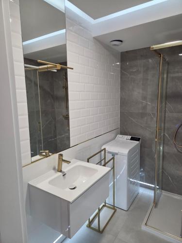 a white bathroom with a sink and a shower at GOLDEN HAUS Opole - Miss Gold & Mini Lux in Opole