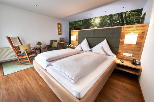 a bedroom with a large bed with a large window at WAGNERS Hotel im Bayerischen Wald in Grafenau