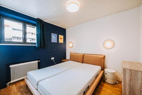 a bed in a room with a blue wall at Villa Limoncello in Hard