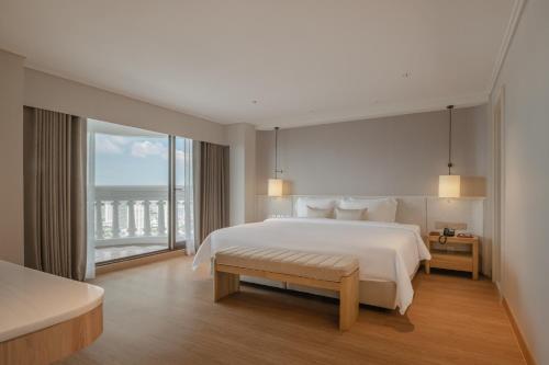 a bedroom with a large bed and a large window at Tower Club at lebua in Bangkok