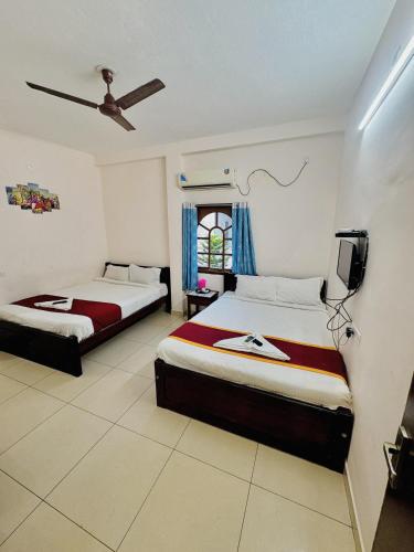 a bedroom with two beds and a tv in it at La town beach stay in Pondicherry