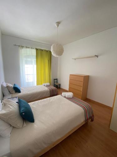 a bedroom with two beds and a window at Casa Ferreira in Beja