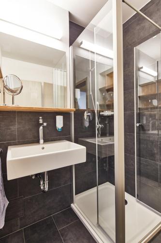 a bathroom with a sink and a shower at WAGNERS Hotel im Bayerischen Wald in Grafenau