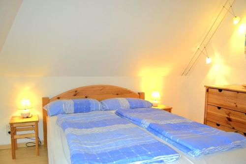 a bedroom with a bed with blue sheets on it at Zaumseil, Axel Fe-App "oben" in Schönberg