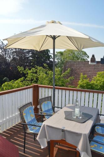 a table and chairs under an umbrella on a deck at Zaumseil, Axel Fe-App "oben" in Schönberg