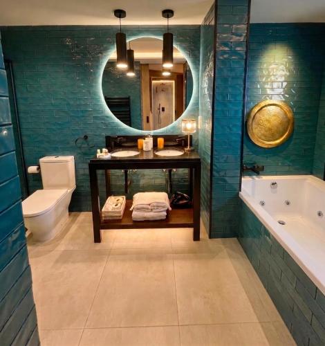 a bathroom with a sink and a tub and a mirror at Casón del Conde in Orgaz
