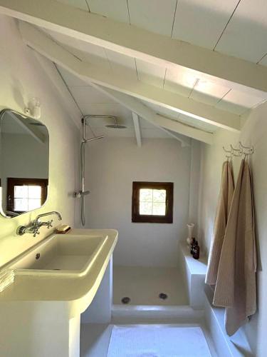 a white bathroom with a sink and a mirror at The Hill House in Argalasti