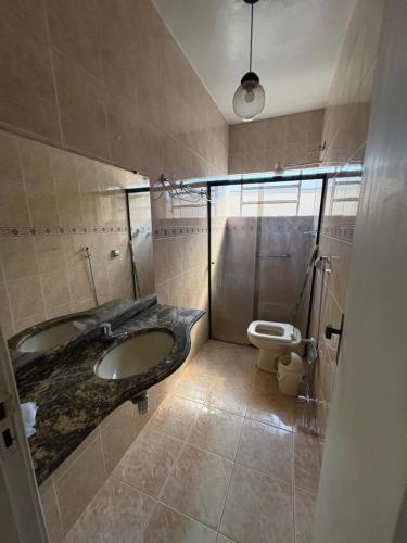 a bathroom with a sink and a toilet at Pousada Dois Irmão in Uberaba