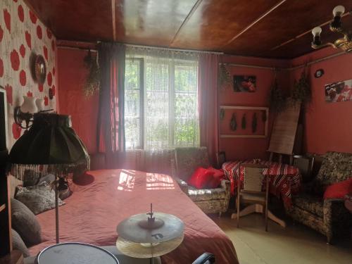 a bedroom with a bed and a table and a window at Bungu Bangu in Ventspils