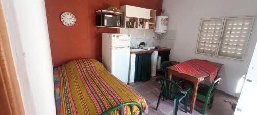 a small kitchen with a table and a refrigerator at Cabaña LDM cc in Santa Rosa