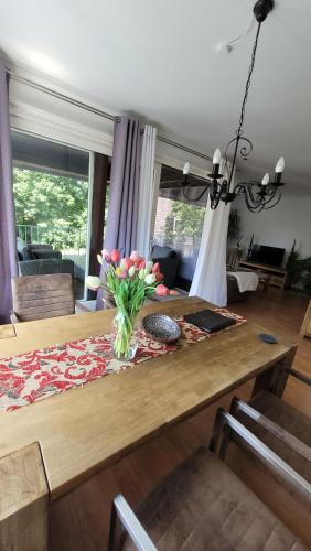a dining room table with a vase of flowers on it at Apartment in Flensburg