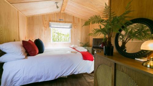 a bedroom with a bed with a mirror and a window at Penrallt in Benllech