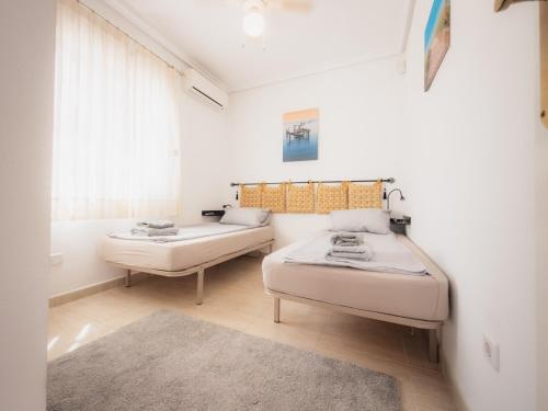 a bedroom with two beds and a window at Luxury Private Pool Villa Campoverde in Pinar de Campoverde