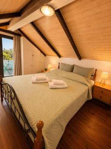 a bedroom with a large bed with two towels on it at Marilena's Houses in Kallithea Rhodes