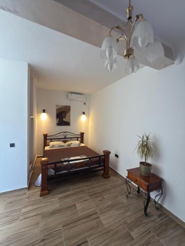 a bedroom with a bed and a table and a chandelier at Alexandra in Prijevor