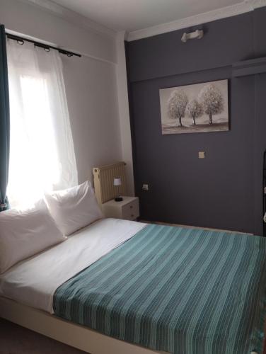 a bedroom with a bed and a window with trees at Αλέξανδρος 3 in Myrina