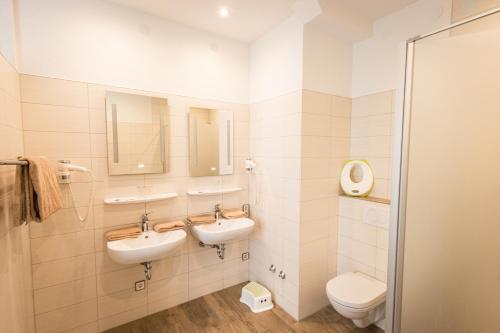 a bathroom with two sinks and a toilet at Hotel Restaurant Ketterer am Kurgarten in Triberg