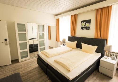 a bedroom with a large bed with white sheets at Hotel Restaurant Ketterer am Kurgarten in Triberg