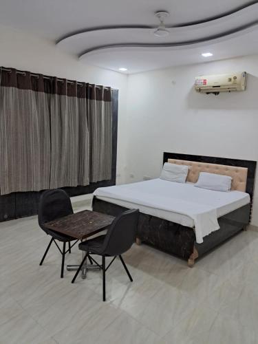 a bedroom with a bed and a table and chairs at PLAY HOTEL PREET RESIDENCY couple friendly in Greater Noida