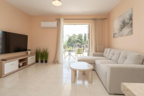 a living room with a couch and a tv at Kos Happy living in Lampi