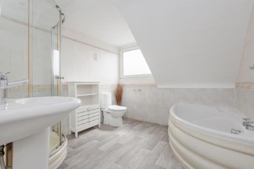 a white bathroom with a toilet and a sink at Talbot House by Grandeur Property in Bournemouth