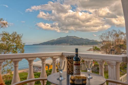 a bottle of wine sitting on a table on a balcony at Saltwater Serenade Apartments in Zakynthos