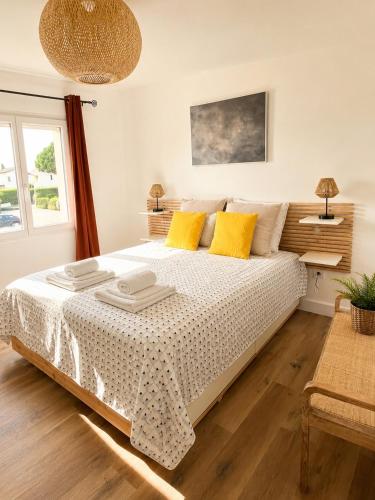 a bedroom with a large bed with yellow pillows at Maison moderne Parking &Jardin in Narbonne